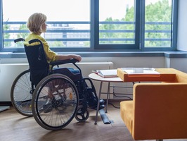 Snimak žene koja sjedi u invalidskim kolicima, u kancelariji